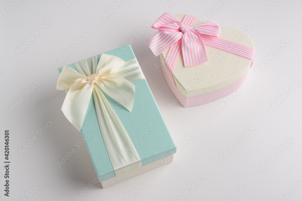 Beautiful gift boxes of different shapes in pink and turquoise colors with a ribbon and a beautifully tied bow on a white background. Festive packaging for a gift or surprise for a loved one. Beautiful gift boxes of different shapes in pink and turquoise colors with a ribbon and a beautifully tied bow on a white background. Festive packaging for a gift or surprise for a loved one.