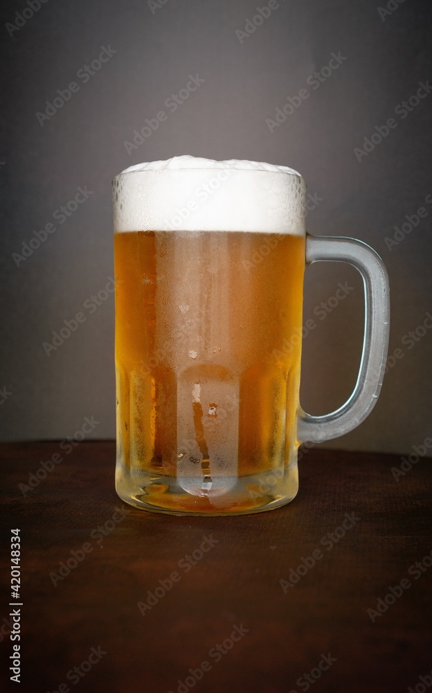 beer chopp on a brown leather-like surface and a black background