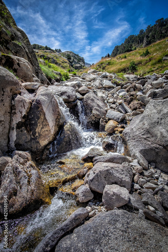 meltwater river flows through a rocky gorge from the top of a mountain, in the natural park of Aiguestortes, in the Catalan Pyrenees of Lerida, Spain
