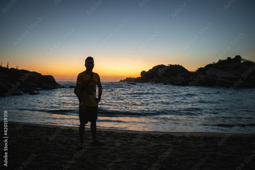 Hombre en la playa viendo el atardecer