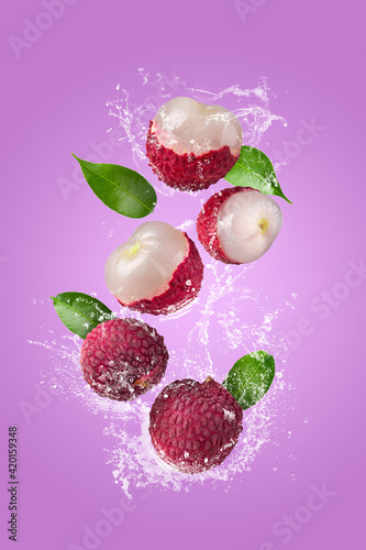 Water Splashing on Fresh lychee or litchi with over pink background photo