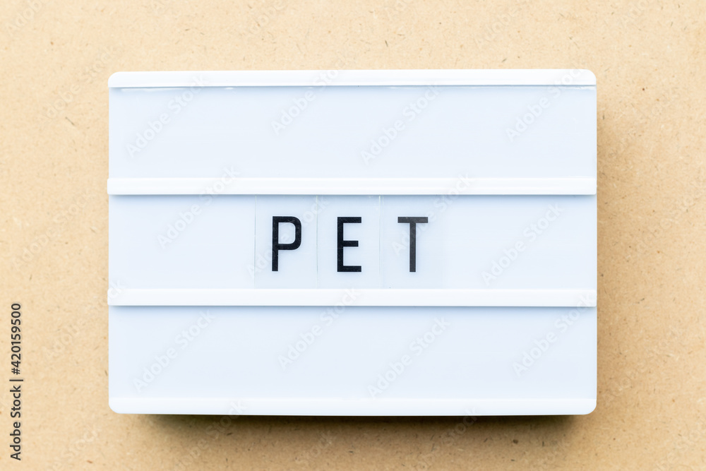 White lightbox with word PET (animal or abbreviation of polyethylene terephthalate) on wood background White lightbox with word PET (animal or abbreviation of polyethylene terephthalate) on wood background