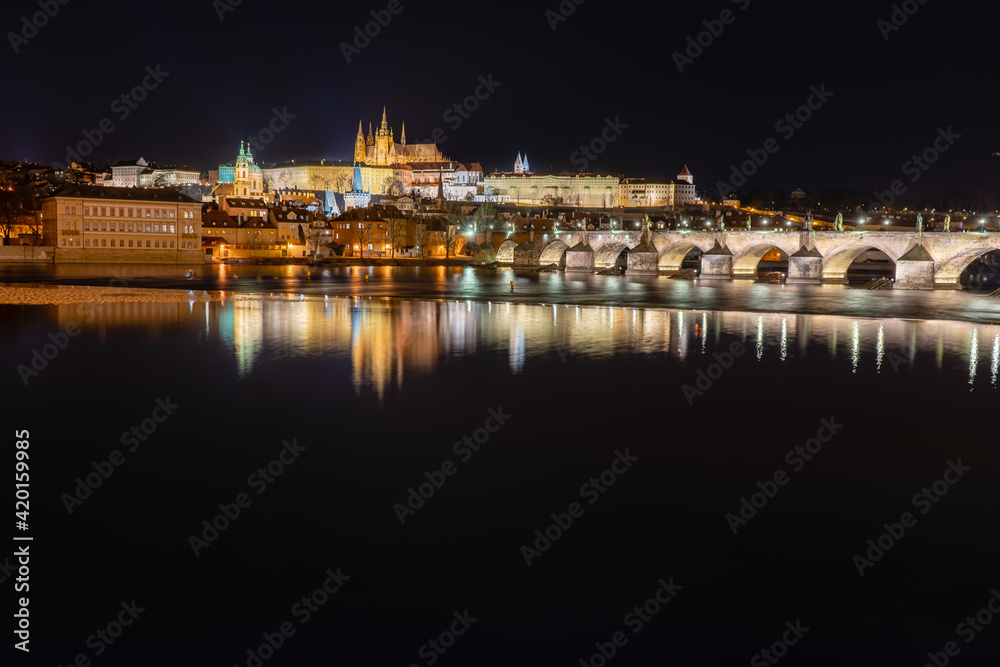 Fototapeta premium .view of the illuminated Prague Castle and the Cathedral of St. Vitus and Charles Bridge on the Vltava River at night in the center of Prague in the Czech Republic