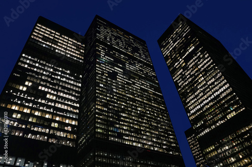 financial district office buildings with windows lit up at night