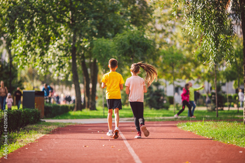 Kids run. Healthy sport. Child sport, heterosexual twins running on track, fitness. Joint training. Running training outdoor brother and sister pre-teen. Jogging with friend. Children athletes © Elizaveta