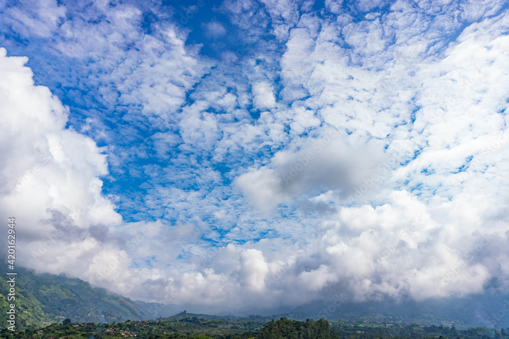 relaxed blue sky with mottled sky above a valley of mountains relaxed blue sky with mottled sky above a valley of mountains