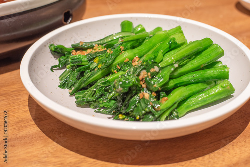 A dish of green vegetables with minced garlic