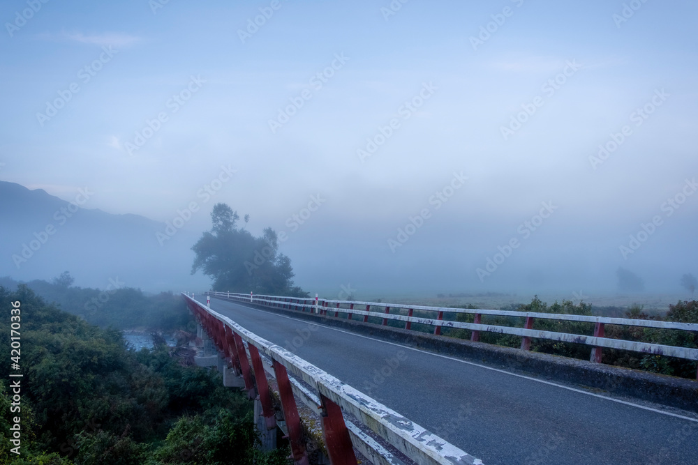 Bridge across the river on a misty morning. South Island, New Zealand. Bridge across the river on a misty morning. South Island, New Zealand.