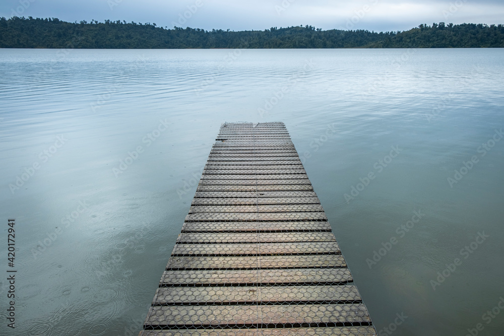 Obraz premium Jetty on the shore of a peaceful lake. South Island, New Zealand.