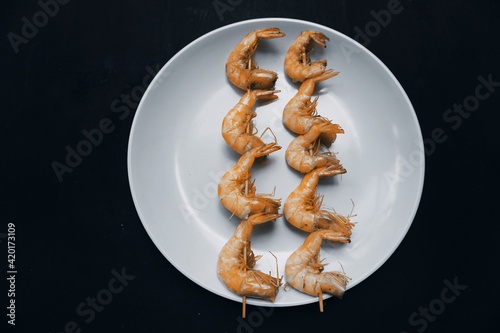 Shrimp satay on plate isolated on black background.