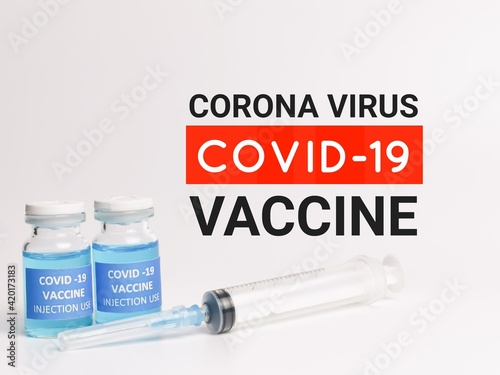 Phrase CORONA VIRUS COVID 19 VACCINE written on white background with two bottles vaccine and syringe.
