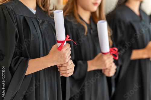 Fotografi group of graduates Asian student in academic gown and graduation holding diploma