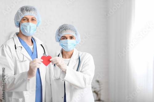 Cardiologists with red heart in clinic