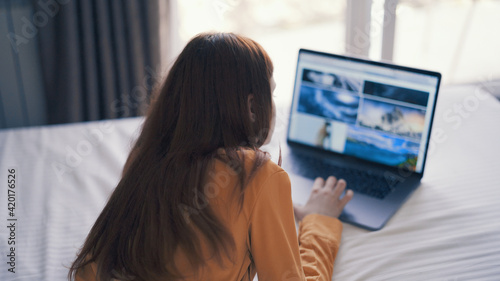 woman in front of laptop lies bed lifestyle freelance