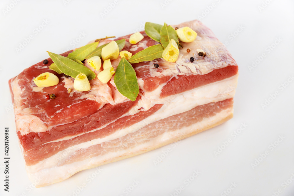 Boneless raw pork belly with garlic isolated on white background. Boneless raw pork belly with garlic isolated on white background.