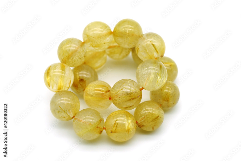 Rutile in quartz gemstone on rock background. Rutile quartz stone beads. Rutile in quartz gemstone on rock background. Rutile quartz stone beads.