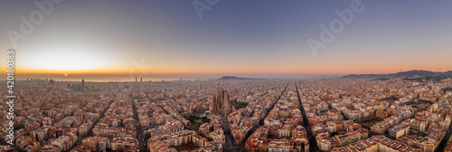 Photography Panoramic aerial drone shot of Barcelona city skyline with church before sunrise