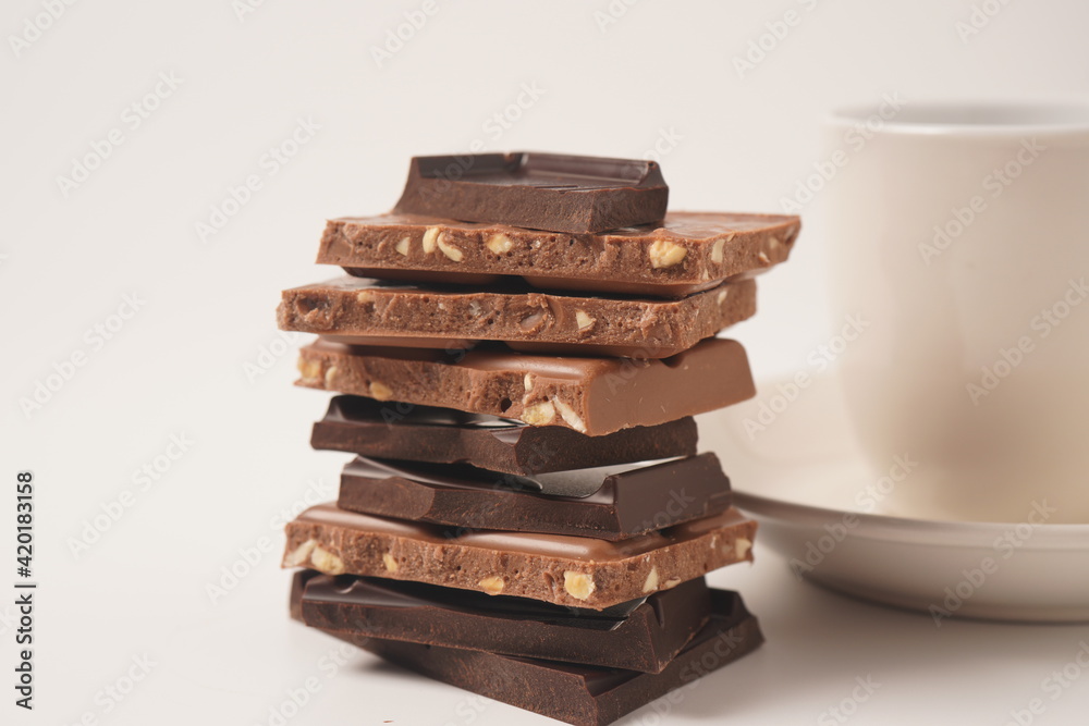 Chocolate tower. Stack of chocolate pieces. The chunks of broken chocolate. Background with chocolate. Chocolate tower. Stack of chocolate pieces. The chunks of broken chocolate. Background with chocolate.