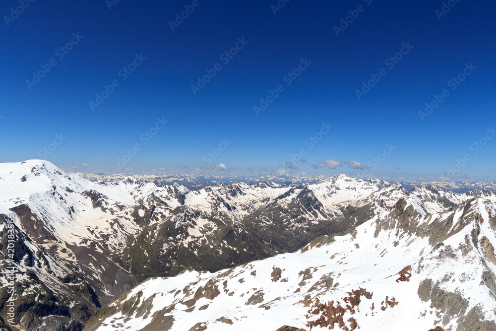 Mountain snow panorama on main chain of the Alps seen from summit Sexegertenspitze and blue sky in Tyrol Alps, Austria
