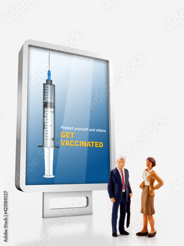 a group of different age people are standing in front of a billboard with a message to get vaccinated against covid-19
