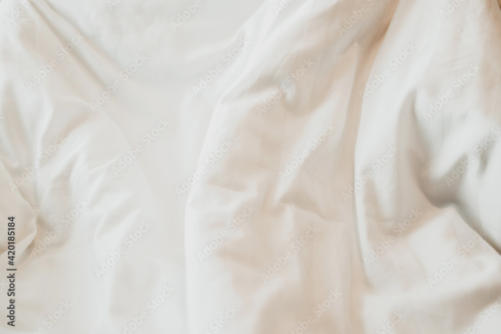 Top view of White duvet on the bed with sunlight. Bedroom with white bed. Top view of White duvet on the bed with sunlight. Bedroom with white bed.