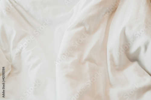 Top view of White duvet on the bed with sunlight. Bedroom with white bed.