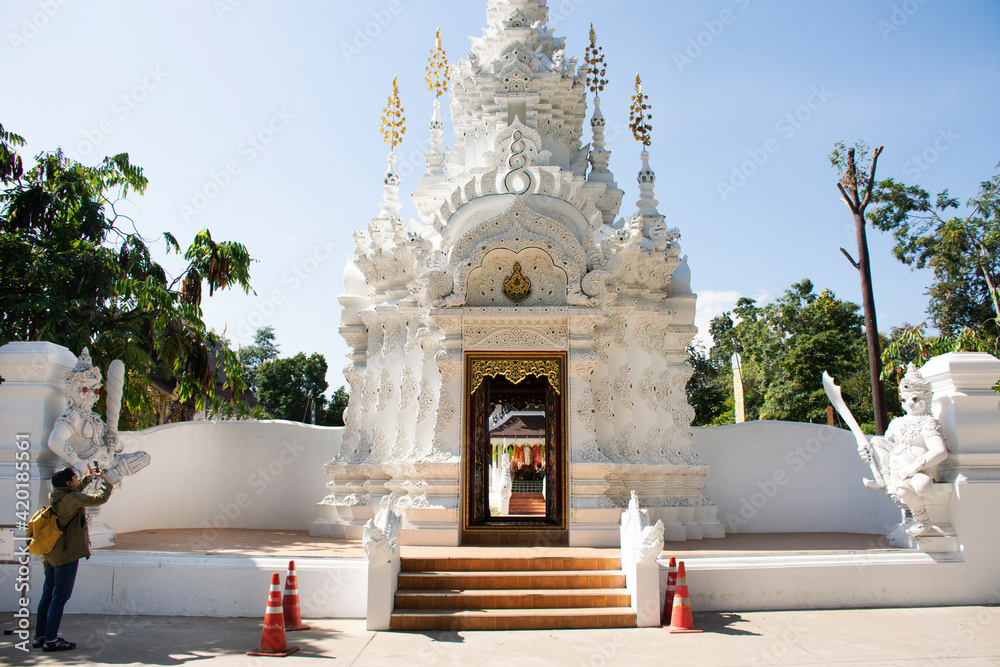 Travelers thai women people travel visit respect praying and take photo Ancient building gate entrance in Wat Pa Daraphirom Temple at Mae Rim city on December 2, 2020 in Chiang Mai, Thailand