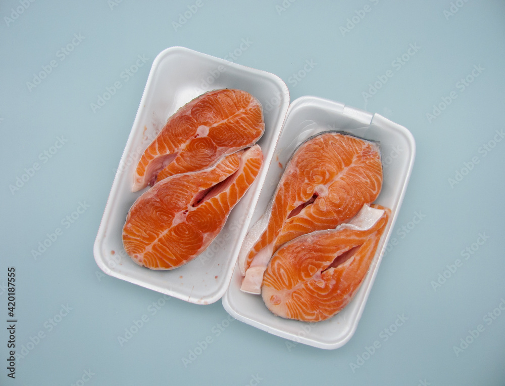 Four pieces of raw fresh salmon steak in a food container Four pieces of raw fresh salmon steak in a food container