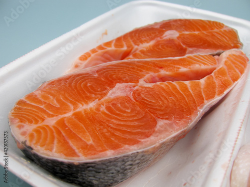 Two pieces of raw fresh salmon steak in a food container