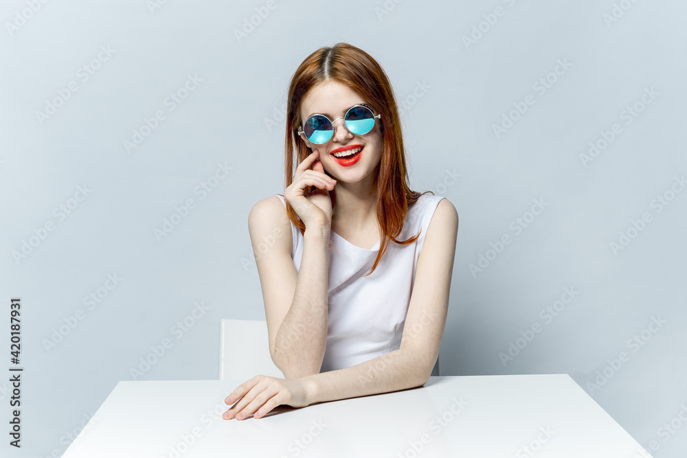 cheerful red-haired woman sitting at the table sunglasses cheerful red-haired woman sitting at the table sunglasses