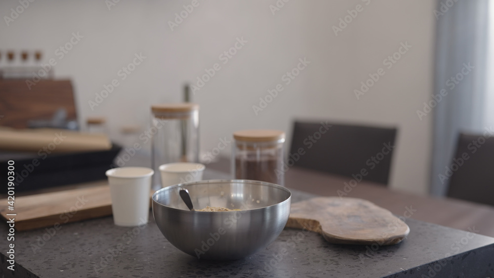 making granola in steel bowl on kitchen countertop making granola in steel bowl on kitchen countertop