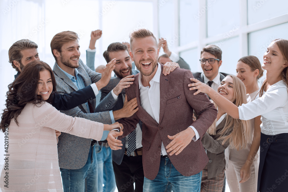 happy team of employees congratulating their colleague. happy team of employees congratulating their colleague.