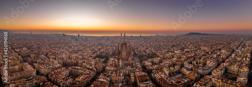 Photography Panoramic aerial drone shot of Barcelona city skyline with church before sunrise