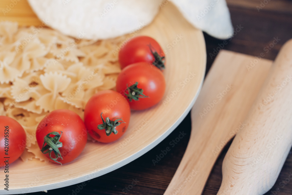 italian pasta on a wooden table cherry tomatoes cooking italian pasta on a wooden table cherry tomatoes cooking
