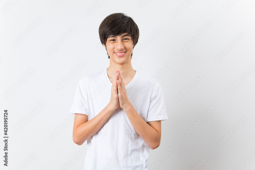 Smiling teen boy greeting with palms gesture pressed together on white background. Smiling teen boy greeting with palms gesture pressed together on white background.