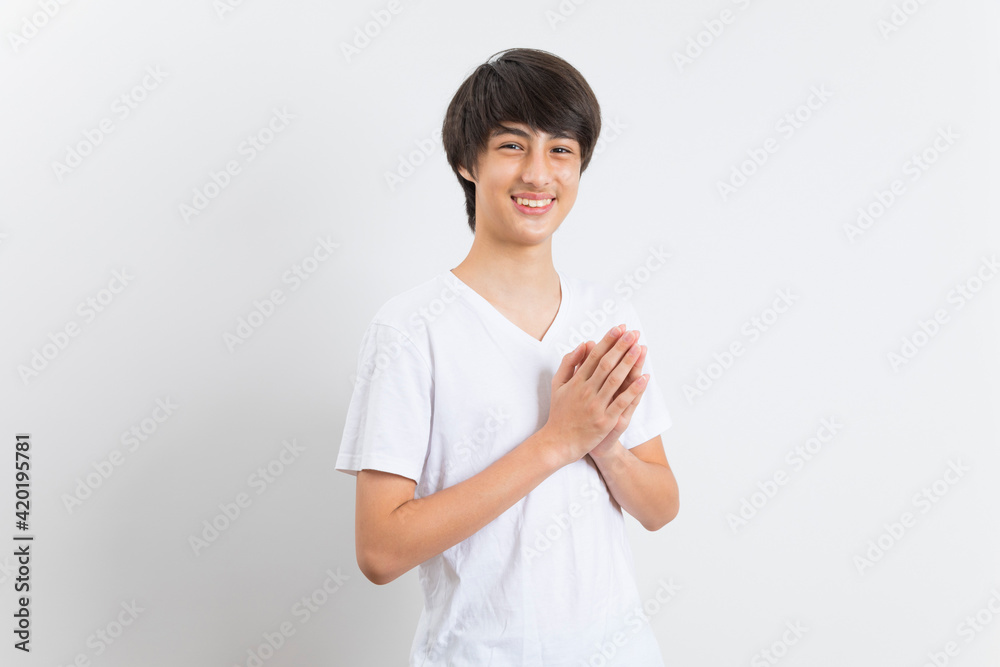 Smiling teen boy greeting with palms gesture pressed together on white background. Smiling teen boy greeting with palms gesture pressed together on white background.