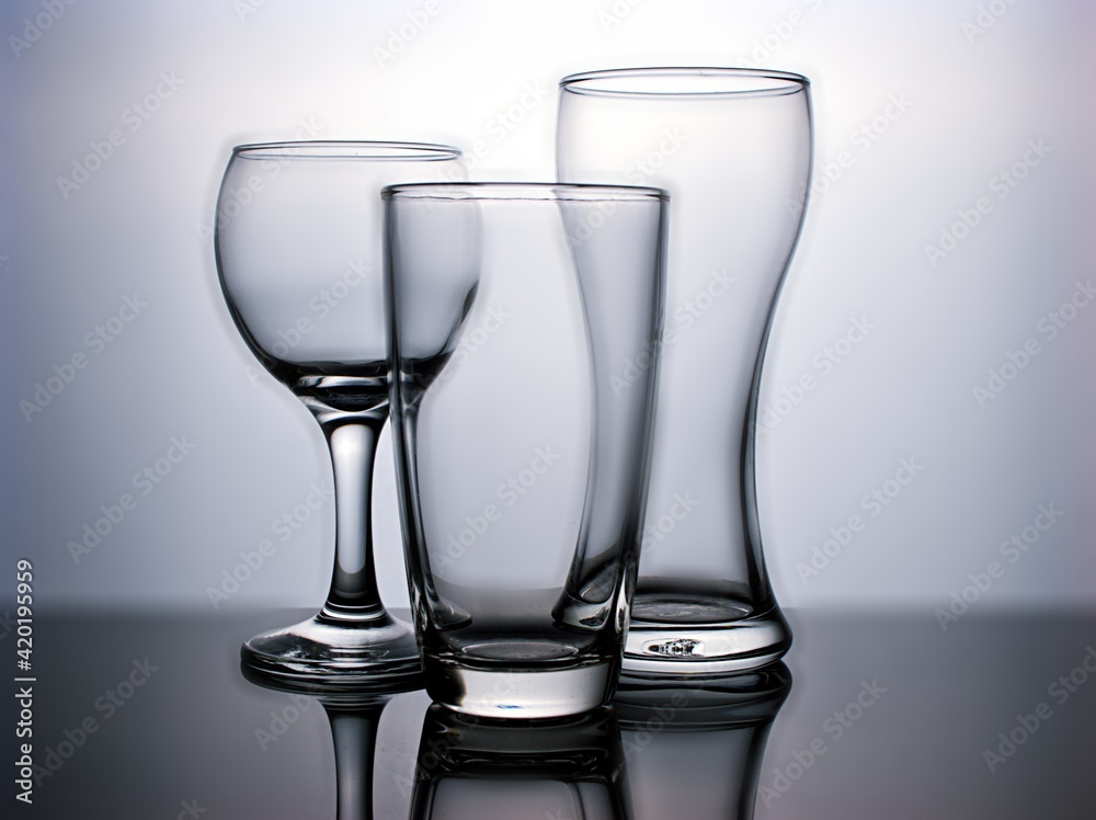 Empty Glass of water shape isolated in black and white background ,empty glass on a table Empty Glass of water shape isolated in black and white background ,empty glass on a table
