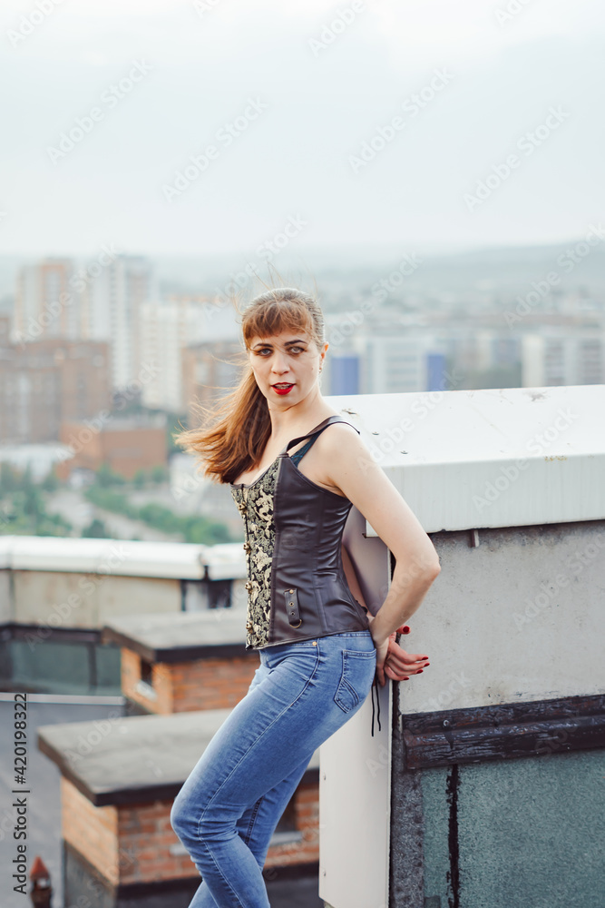 beautiful girl standing on the roof of the house