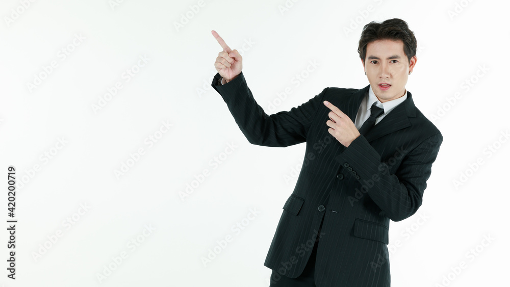 Portrait of self-confidence young and handsome Asian businessman in black suit standing in elegant pose and pointing finger, copy space studio shot isolated on white background Portrait of self-confidence young and handsome Asian businessman in black suit standing in elegant pose and pointing finger, copy space studio shot isolated on white background