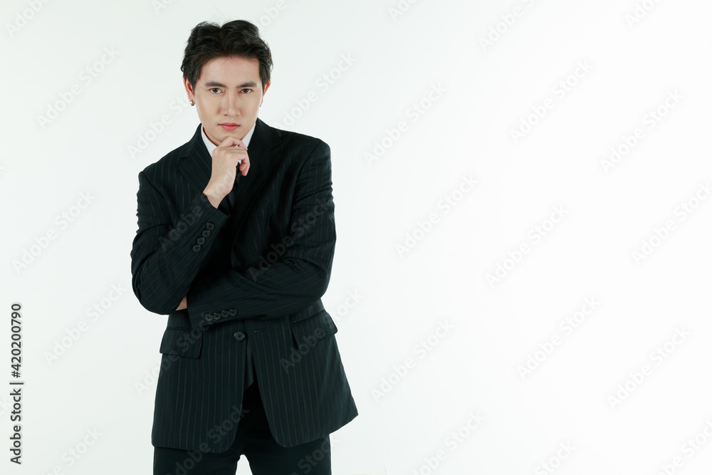 Portrait of self-confidence young and handsome Asian businessman executive looked in black suit standing and touch his chin in thinking pose, copy space studio shot isolated on white background Portrait of self-confidence young and handsome Asian businessman executive looked in black suit standing and touch his chin in thinking pose, copy space studio shot isolated on white background