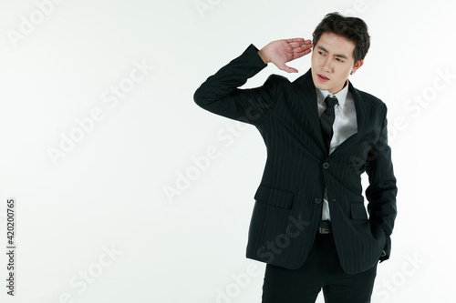 Portrait of self-confidence young and handsome Asian businessman in black suit standing and raise hands ready for hearing and listening, copy space studio shot isolated on white background photo