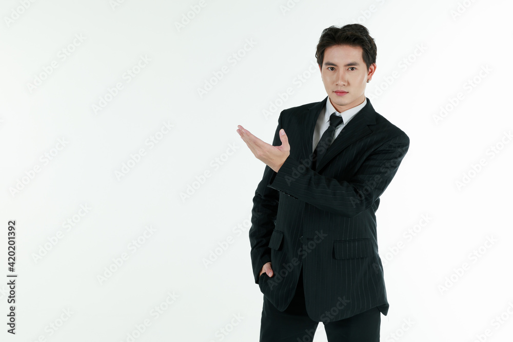 Portrait of self-confidence young and handsome Asian businessman in black suit standing in elegant pose and pointing finger, copy space studio shot isolated on white background Portrait of self-confidence young and handsome Asian businessman in black suit standing in elegant pose and pointing finger, copy space studio shot isolated on white background