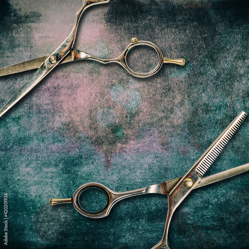 Hairdressing scissors on a dark, shabby grunge background. Copy space.