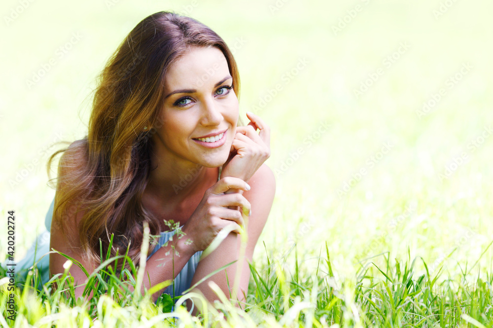 young woman lying on grass