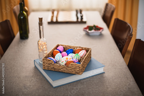 cesta de huevos de pascua sobre un libro en mesa de comedor