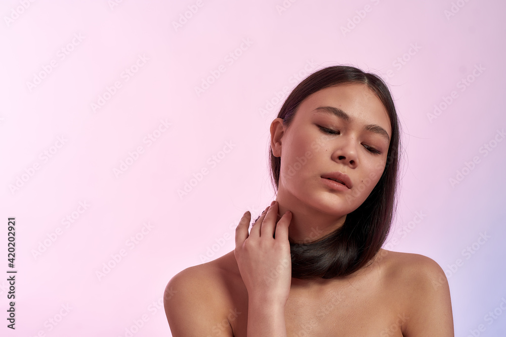 Young gorgeous asian woman touching her healthy and strong long hair and looking down Young gorgeous asian woman touching her healthy and strong long hair and looking down