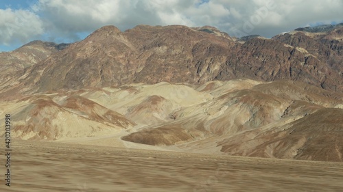 Road trip to Death Valley  Artists Palette drive  California USA. Hitchhiking auto traveling in America. Highway  colorful bare mountains and arid climate wilderness. View from car. Journey to Nevada.