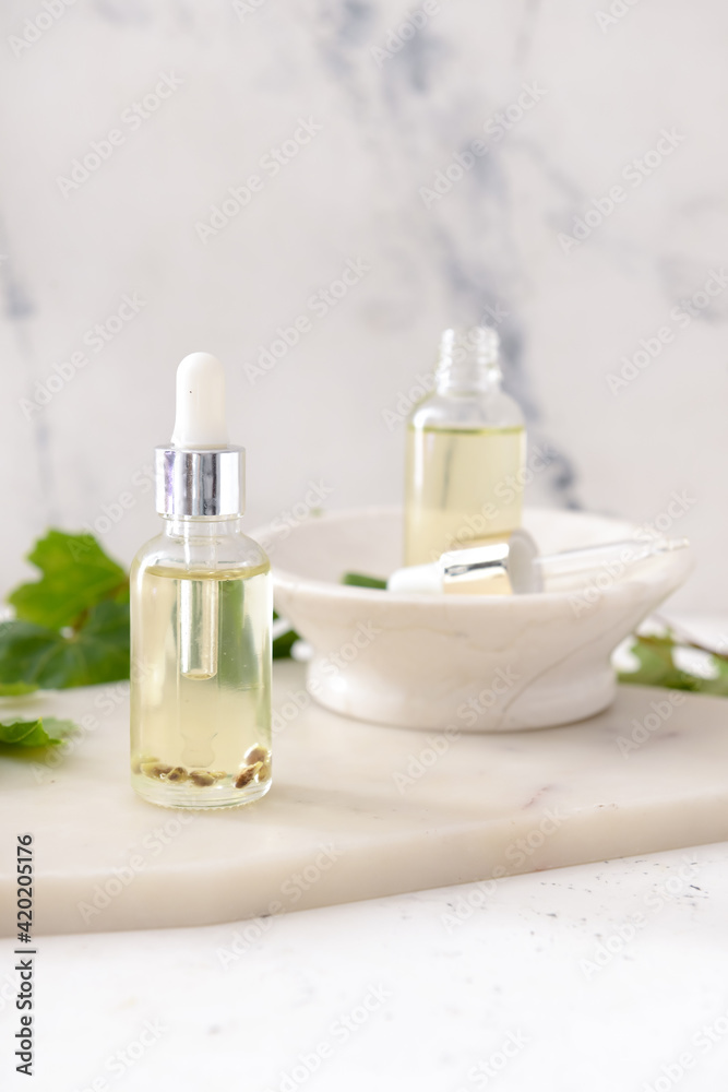 Bottles of grape seed oil on white background Bottles of grape seed oil on white background