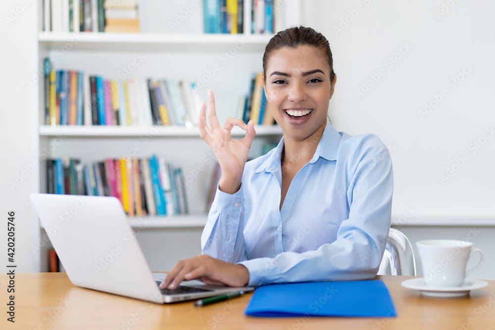 Motivated latin american business trainee working at computer