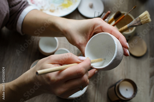 Hand-painting homemade ceramic dishes.
